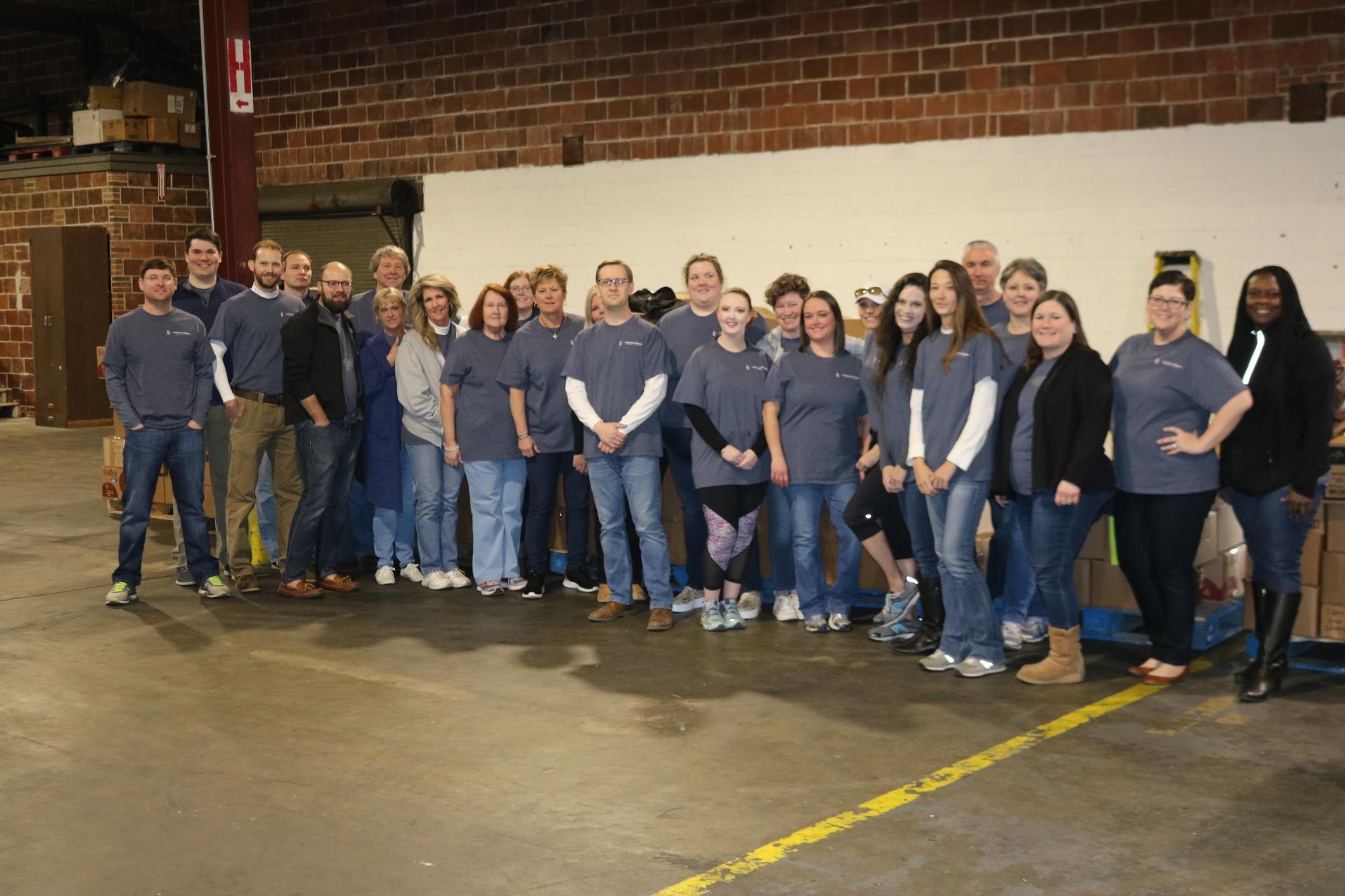 a group of people standing in front of a crowd posing for the camera