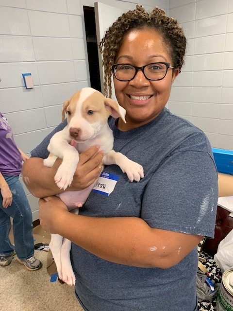 a woman holding a dog posing for the camera